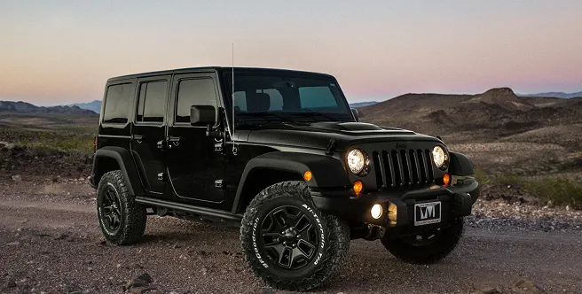 Siyah bir Jeep Wrangler çöl yolunda gün batımında park halinde, Allianz kasko güvencesi ile seyahat ediyor.