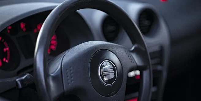 Kasko ve trafik sigortası güvencesindeki Seat marka aracın direksiyonu ve kırmızı ışıklı gösterge paneli.