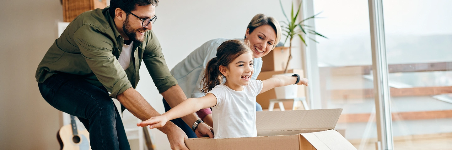 Allianz güvencesiyle evlerinde huzurlu ve mutlu zaman geçiren, yatakta oyun oynayan anne, baba ve kız çocuğu.