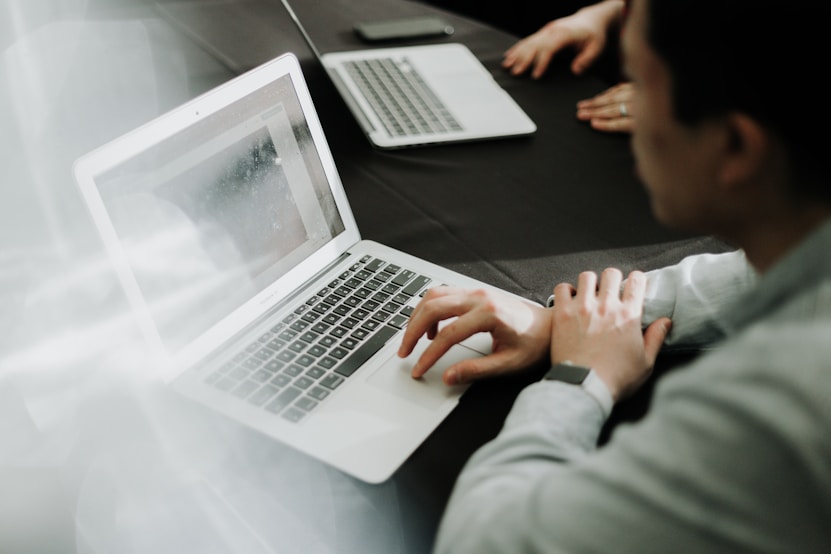 Siyah bir masada dizüstü bilgisayar kullanarak Allianz online sigorta işlemlerini gerçekleştiren bir profesyonel.