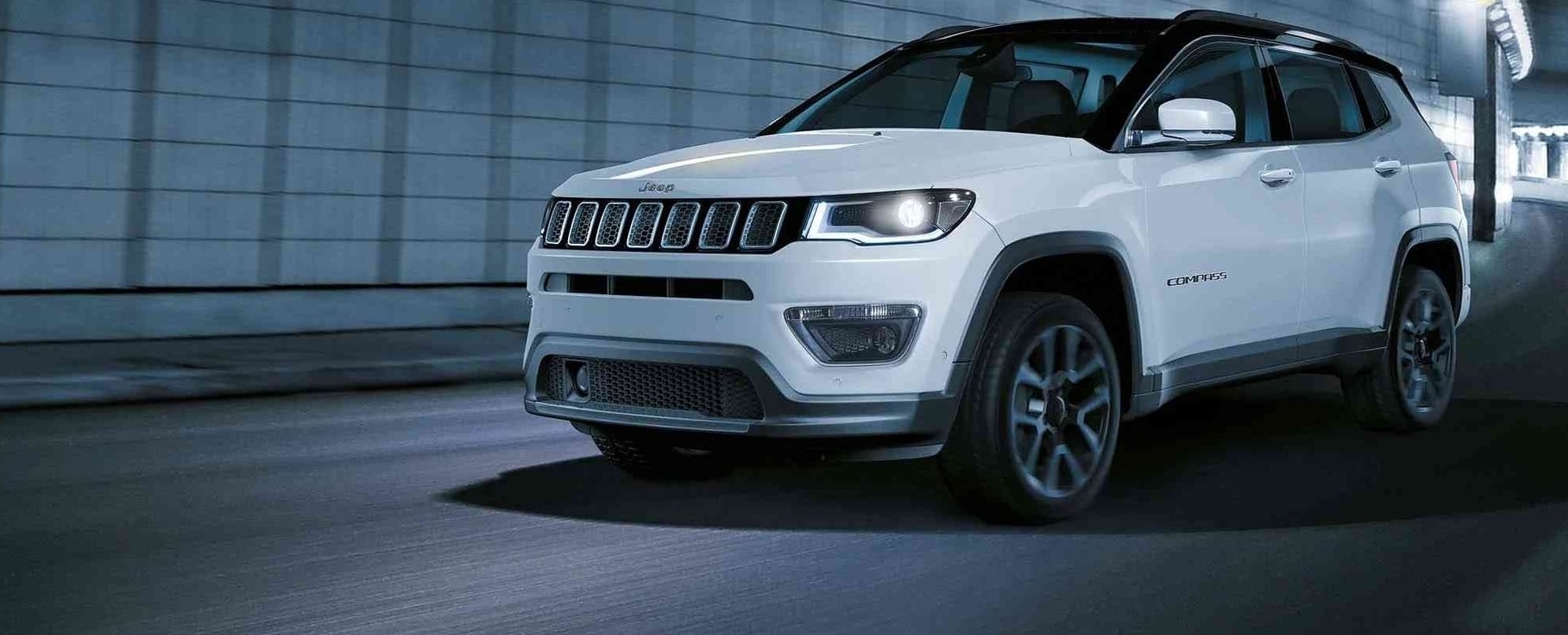 Siyah renkli Jeep marka aracın ön kaputu üzerinde gümüş renkli Jeep logosu ve ön panjur detayı.
