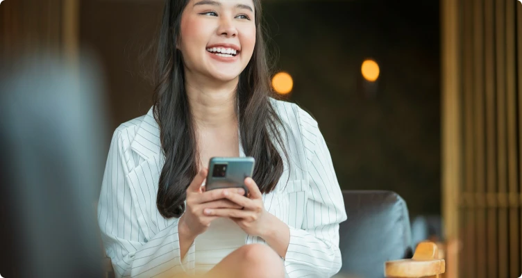 Akıllı telefonunda Allianz Türkiye uygulamasını kullanan, gülümseyen genç kadın.