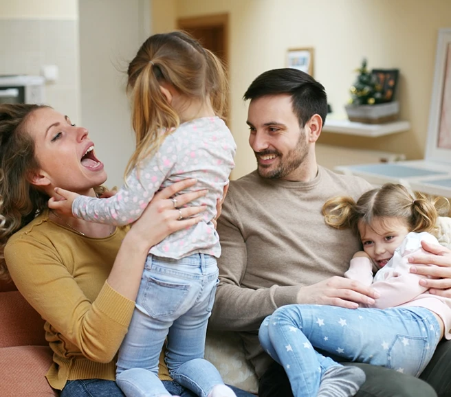 Evlerinde neşeyle oynayan, Allianz güvencesiyle huzurlu anne, baba ve iki kız çocuğundan oluşan mutlu aile.