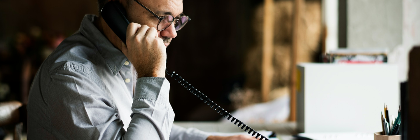 Allianz Türkiye sigorta danışmanı ofisinde sabit telefonla müşterilerine destek veriyor.