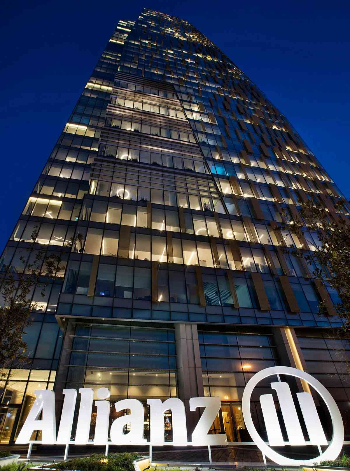Allianz Türkiye'nin modern cam cepheli genel merkez binası, gece çekimi, ışıklı Allianz logosu ile.