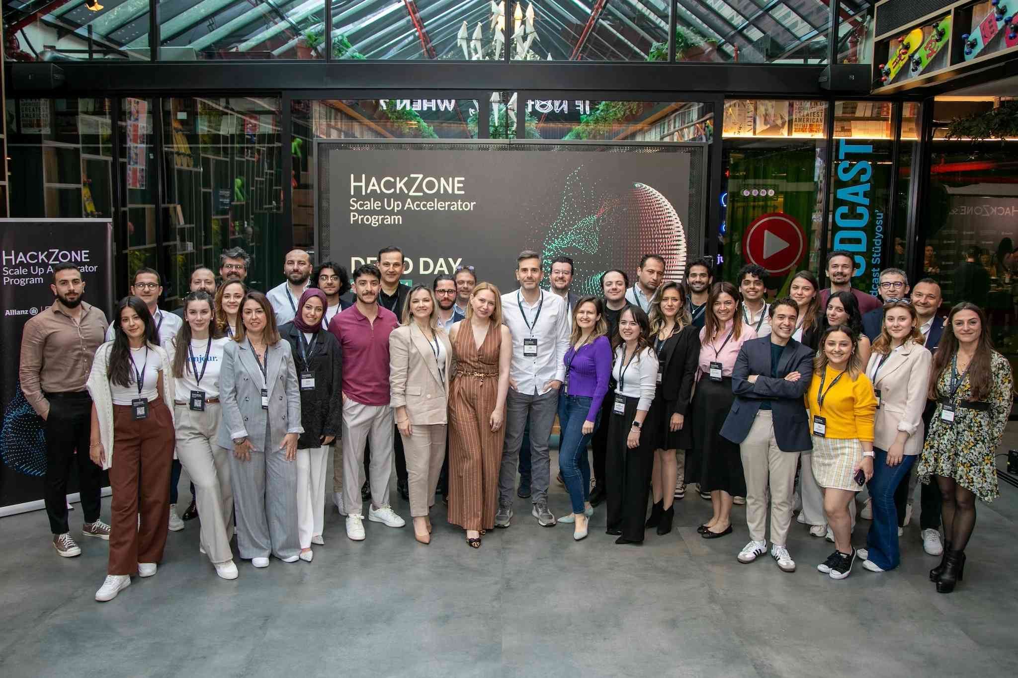 Allianz Hackzone Scale Up Hızlandırma Programı Demo Günü katılımcıları ve ekip üyeleri bir arada, büyük ekran önünde.